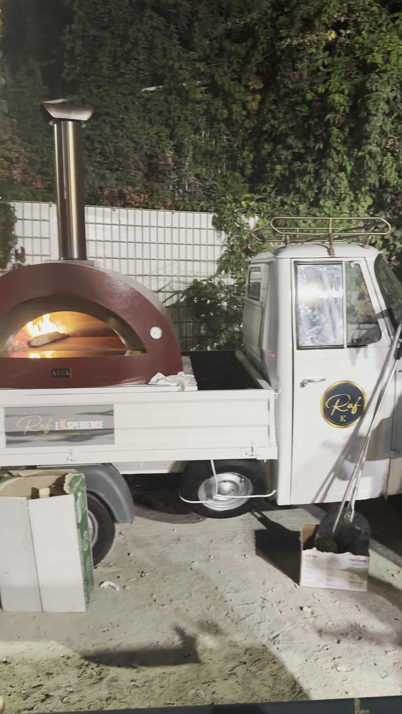 L'Apecar con il forno a legna acceso in giardino di notte