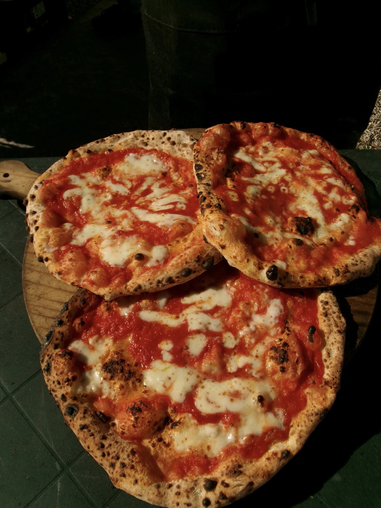 Pizza appena sfornata sul tagliere di legno